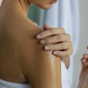 Жена след баня си нанася арганово масло на тялото